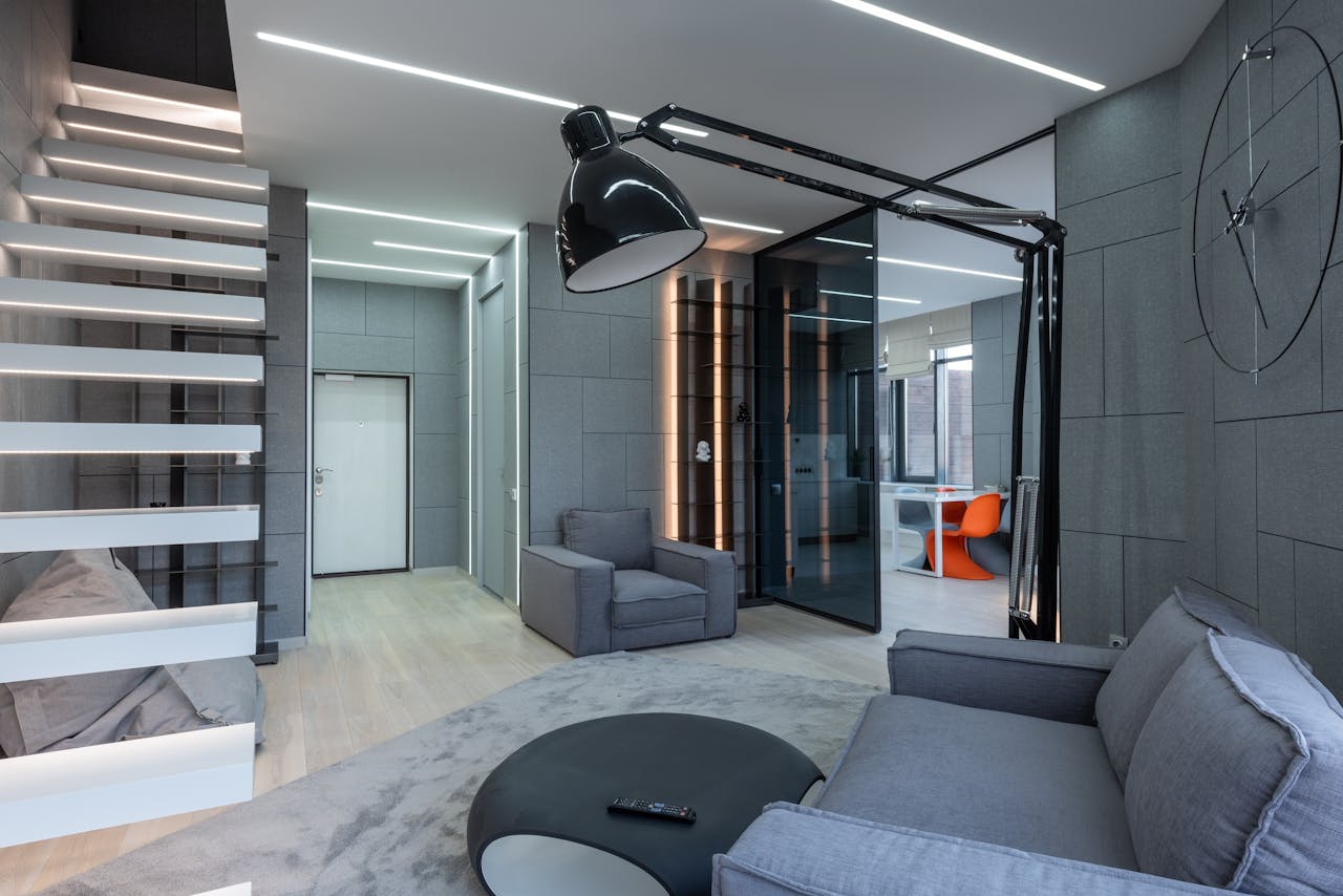 A sleek contemporary living room featuring minimalist furniture and modern lighting design.